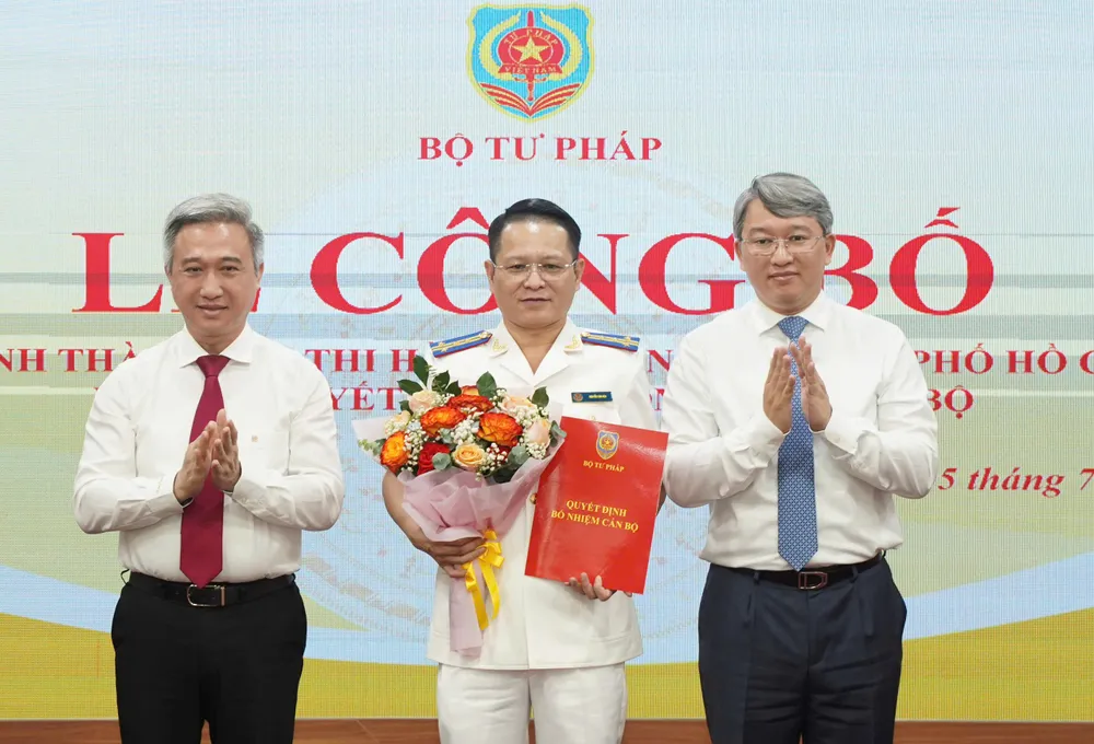 Bộ trưởng Bộ Tư pháp Nguyễn Hải Ninh (bên phải) và Phó Bí thư Thành ủy TPHCM Đặng Minh Thông trao quyết định bổ nhiệm và hoa chúc mừng ông Nguyễn Văn Hòa z6773463224029_febbdf38f9ec148ebc812a37cf882183.jpg