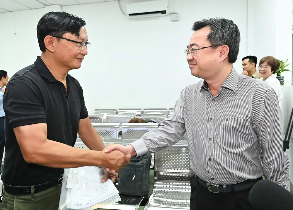 Đồng chí Nguyễn Thanh Nghị trò chuyện với người dân đến thực hiện thủ tục hành chính. Ảnh: VIỆT DŨNG z6792769321386_bf392e112955627cf1142deb64b3b564.jpg