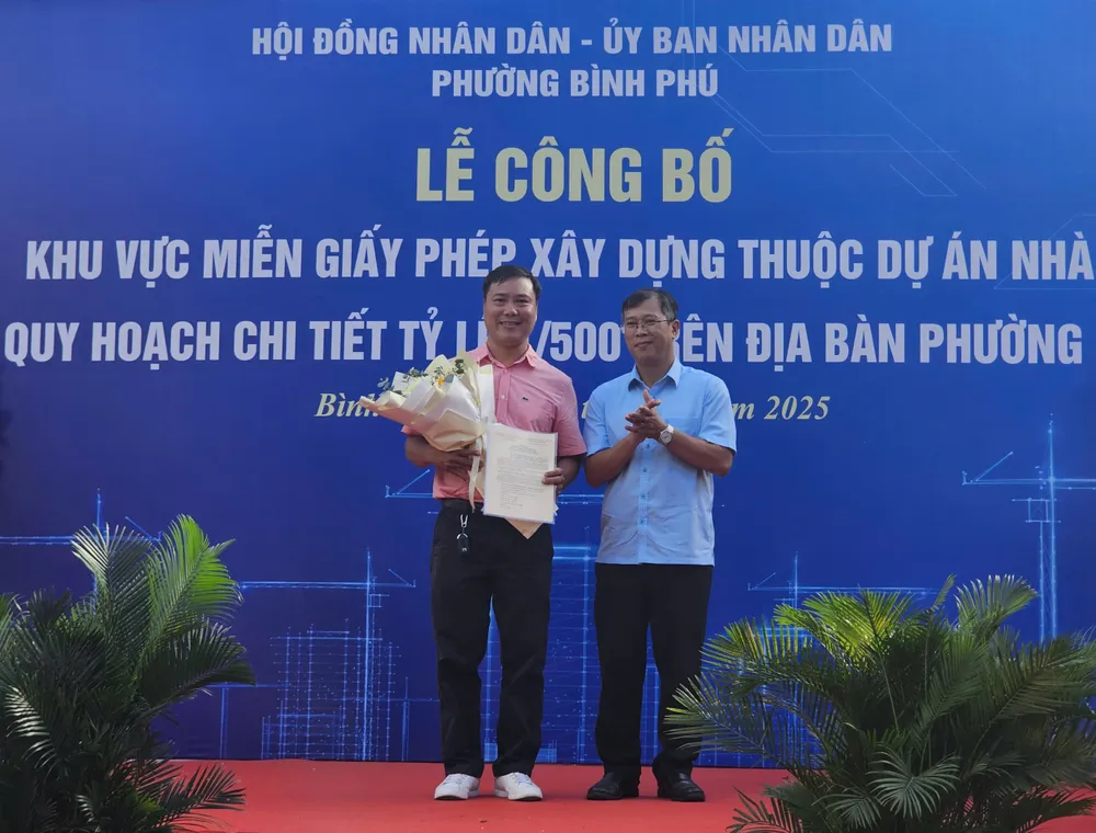 Anh Ngô Thế Minh (bên trái) là một trong những người dân đầu tiên hưởng chính sách miễn giấy phép xây dựng z6861722535365_f13eb76b76ee40261768aadce9a8d5bf.jpg