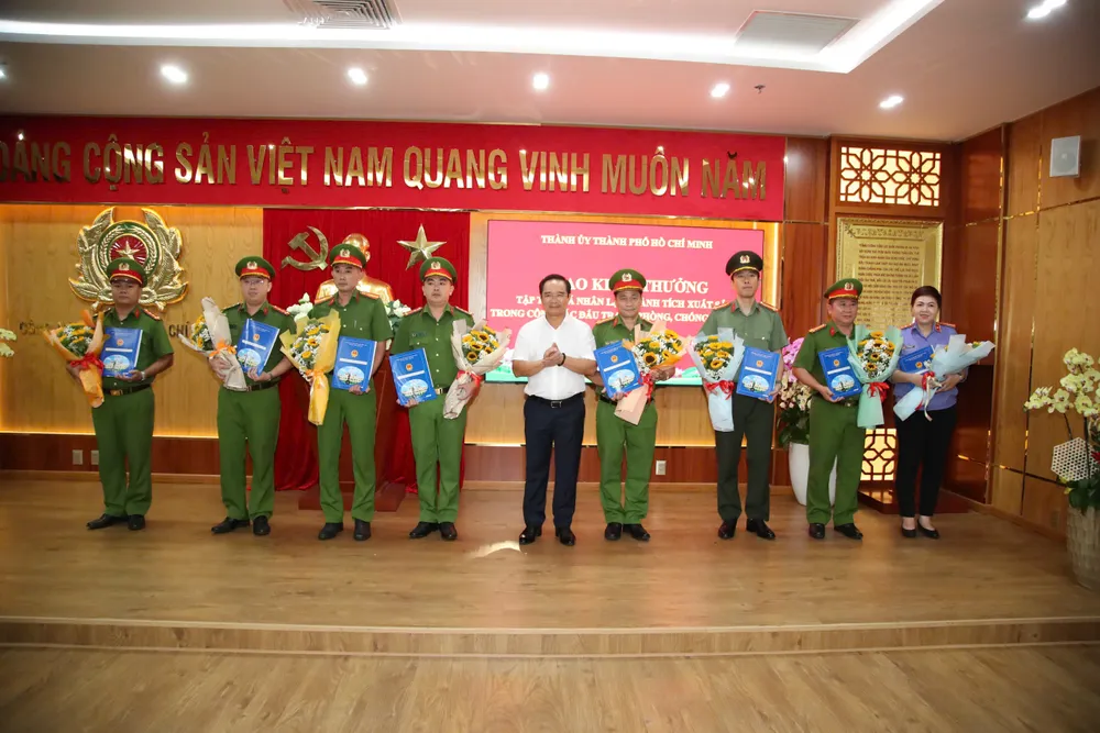 Đồng chí Nguyễn Văn Được trao thưởng và tặng hoa chúc mừng 4 tập thể và 4 cá nhân. Ảnh: CATP z6913698079122_039c403fa7c45d31de9ffa8c61f4d080.jpg