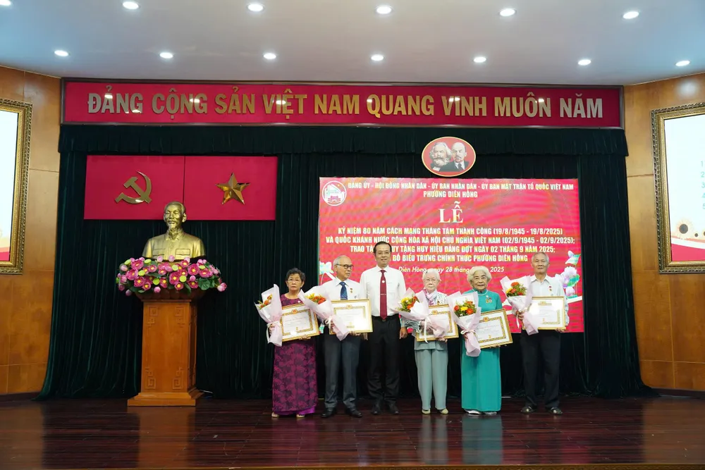 Đồng chí Lê Văn Minh trao Huy hiệu Đảng đến các đảng viên. Ảnh: TIỂU NGHĨA z6952873945394_b42cfa0888ed68e81bf9fb054059e8c1.jpg
