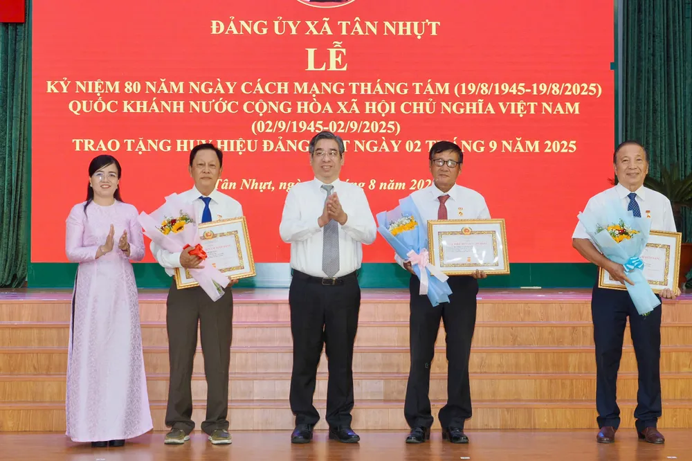 Phó Bí thư Thành ủy TPHCM Nguyễn Phước Lộc cùng lãnh đạo xã Tân Nhựt trao Huy hiệu Đảng. Ảnh: HOÀNG HÙNG z6953695459474_3df434d99a37678c3a40daaa7e3f807b.jpg