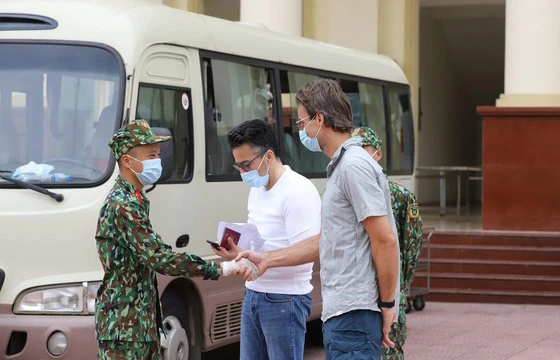 Cán bộ, chiến sĩ tại khu vực cách ly Trường Quân sự, Bộ Tư lệnh Thủ đô chúc mừng khách nước ngoài đã hoàn thành thời gian cách ly khi đến Việt Nam từ vùng dịch. Ảnh: VIẾT CHUNG