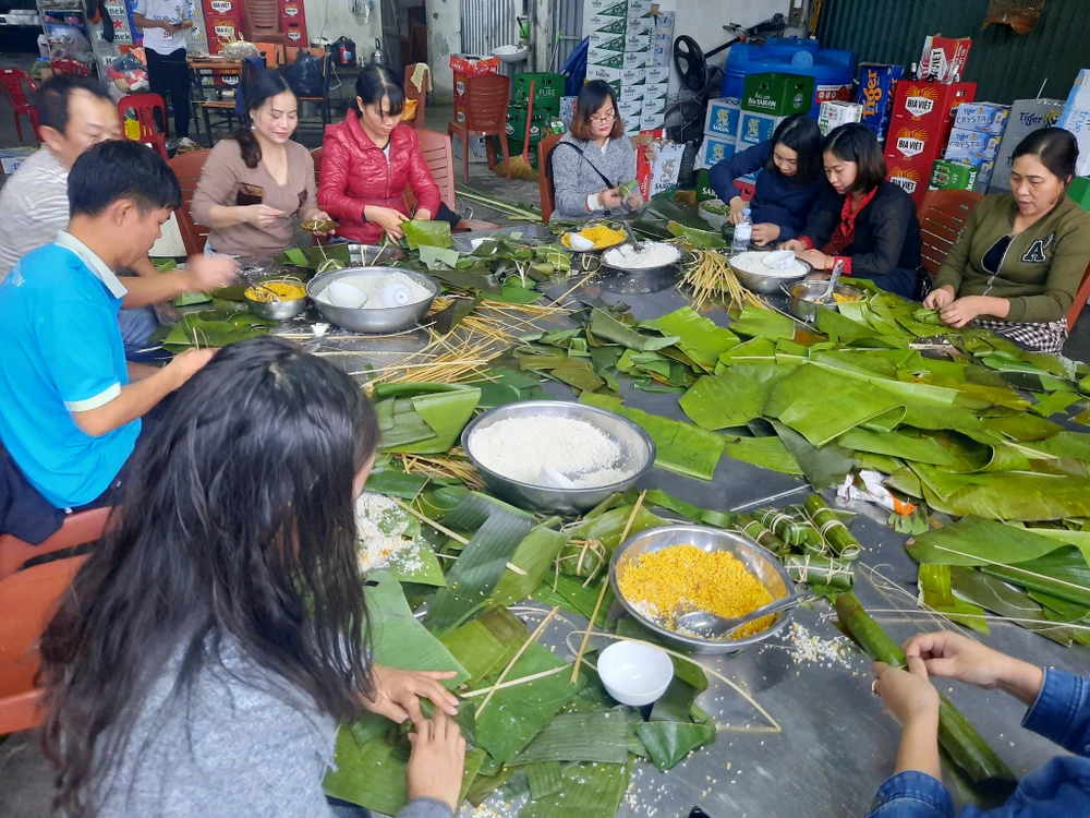 Người dân TP Vinh (Nghệ An) gói bánh chưng chuyển vào ủng hộ đồng bào bị lũ lụt. Ảnh: TRẦN TRUNG HIẾU