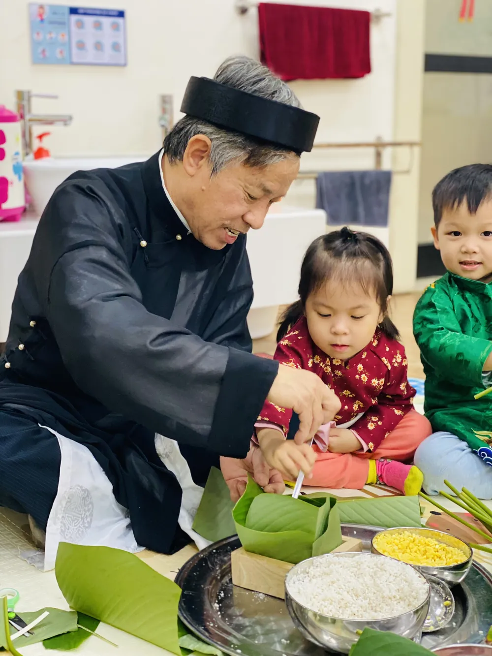 Trẻ mầm non được trải nghiệm hoạt động gói bánh chưng ngay tại trường học