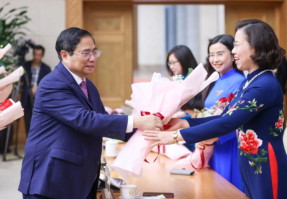 Thủ tướng Phạm Minh Chính tặng hoa chúc mừng các đại biểu. Ảnh: VIẾT CHUNG