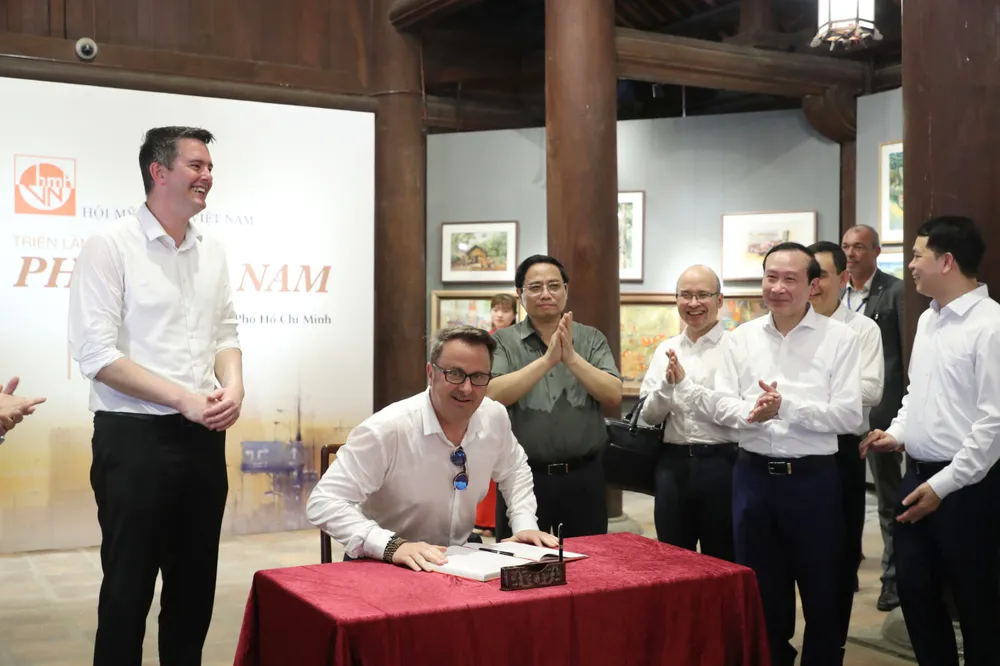 Thủ tướng Luxembourg Xavier Bettel viết sổ lưu niệm ở Văn Miếu – Quốc Tử Giám. Ảnh: QUANG PHÚC