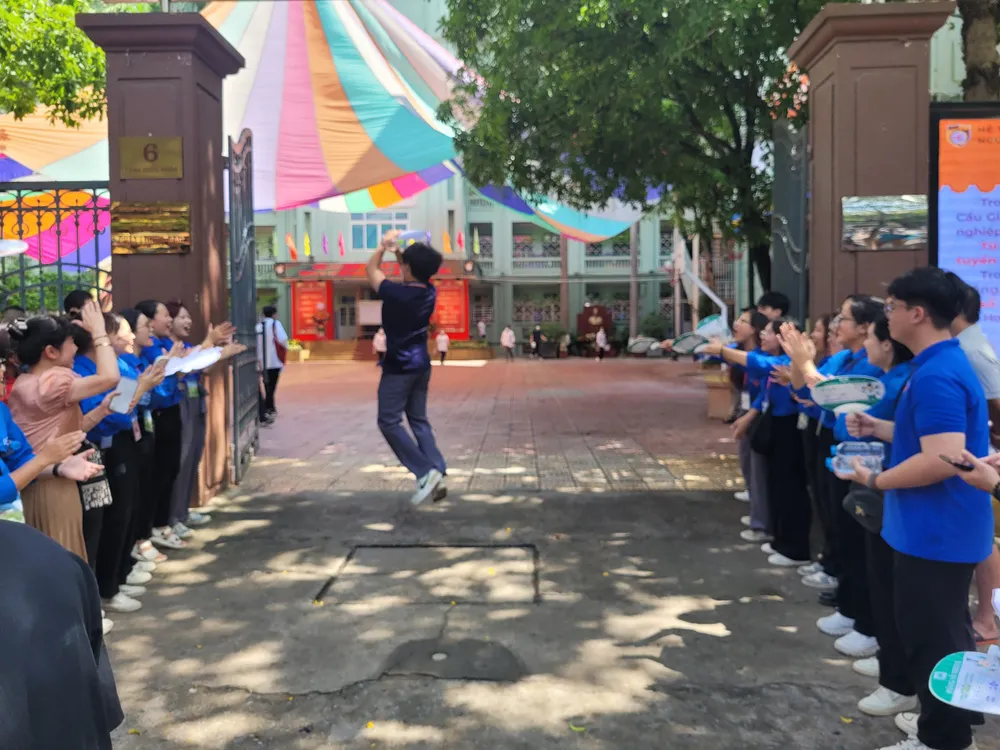 Một thí sinh phấn khích nhảy cẫng lên ăn mừng khi ra khỏi phòng thi được thanh niên tình nguyện cổ vũ tinh thần để thi tốt. Ảnh: PHAN THẢO