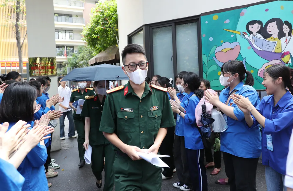 Thanh niên tình nguyện chúc mừng thí sinh ra khỏi phòng thi. Ảnh: QUANG PHÚC