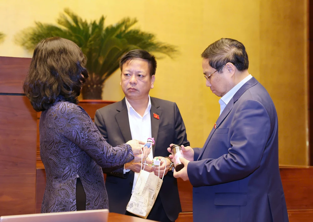Bộ trưởng Bộ Y tế Đào Hồng Lan mang thuốc lá điện tử đến nghị trường Quốc hội và trao đổi với Thủ tướng Phạm Minh Chính. Ảnh: QUANG PHÚC 1.jpg