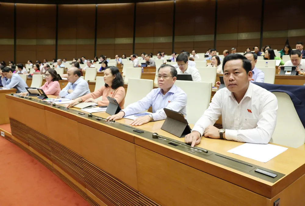 Đại biểu Quốc hội bấm nút biểu quyết thông qua luật. Ảnh: QUANG PHÚC Đại biểu Quốc hội bấm nút biểu quyết thông qua các luật, nghị quyết.jpg