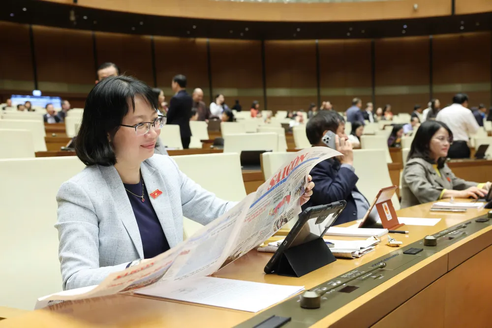 Anggota DPR membaca koran SGGP pada pagi hari tanggal 8 Desember. Foto: QUANG PHUC 1a.jpg