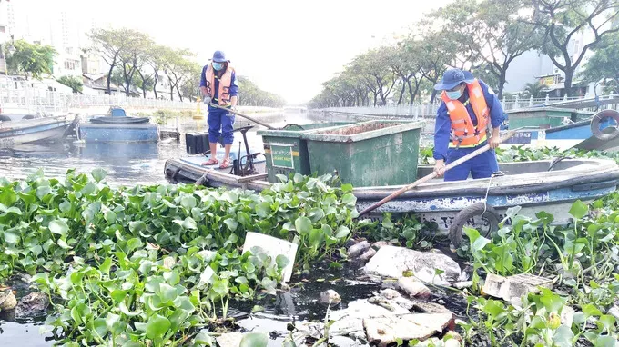Công nhân Công ty Môi trường đô thị TPHCM vớt rác trên tuyến kênh Tân Hóa - Lò Gốm. Ảnh: MH vot-rac.jpg