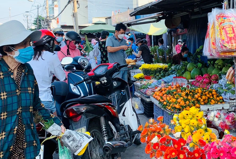 Khách đi chợ mua trái cây, hoa tươi vía Thần Tài. Ảnh: THI HỒNG