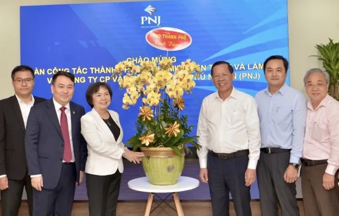 Chủ tịch UBND TPHCM Phan Văn Mãi tặng hoa chúc mừng bà Cao Thị Ngọc Dung tại Công ty PNJ. Ảnh: CAO THĂNG
