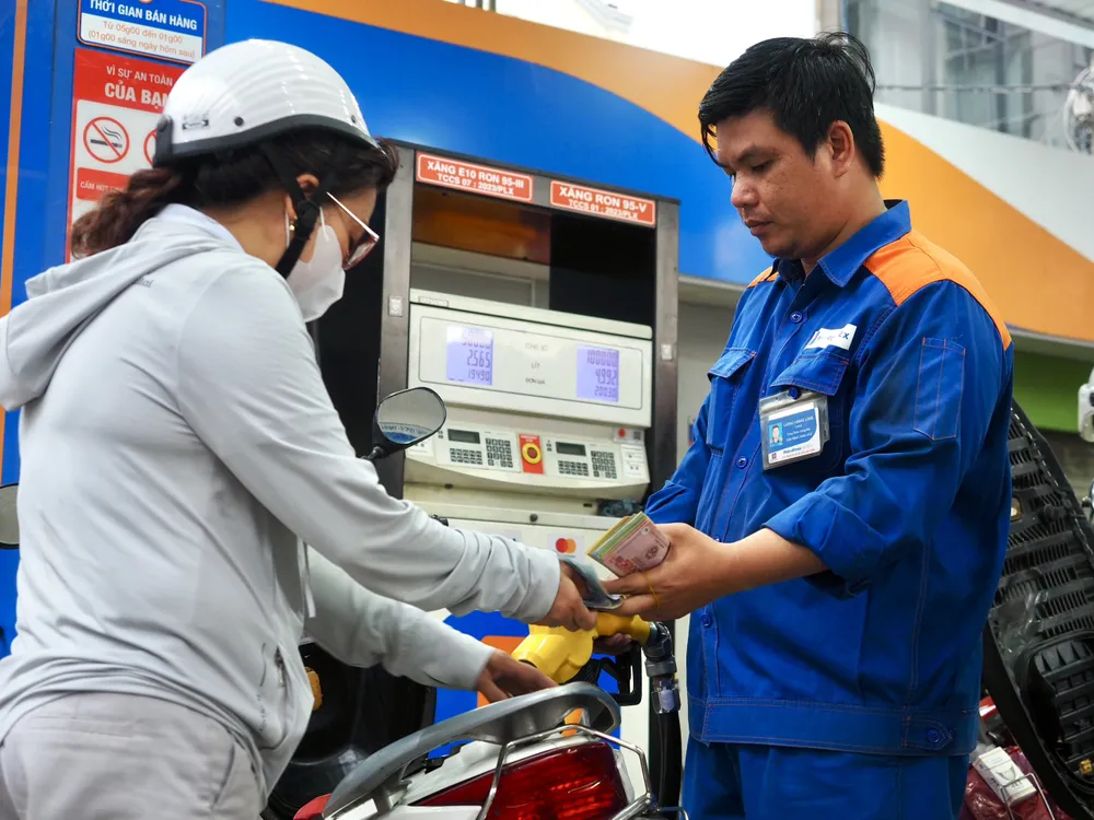 Khách đổ xăng E10 và thanh toán tiền. Giá bán niêm yết mới nhất vào chiều 31-7 là 19.600 đồng/lít xăng E10 RON95-III (giá vùng 1) và 19.990 đồng/lít (giá vùng 2). Ảnh: HOÀNG HÙNG Trả tiền xăng E10.jpg