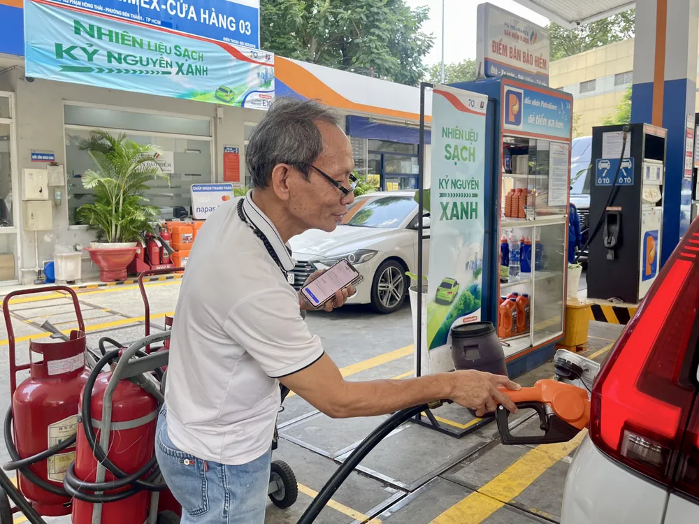 Người dân đổ xăng vào chiều 1-8 tại cây xăng Petrolimex thuộc phường Bến Thành, TPHCM. Ảnh: HOÀNG HÙNG Xăng e10.jpg