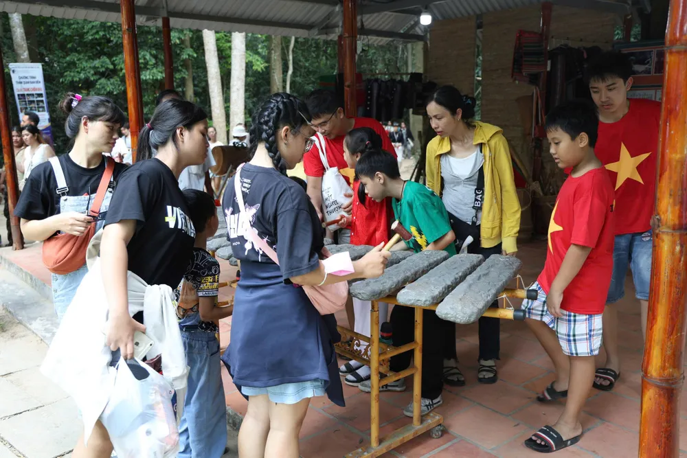 Khách du lịch háo hức tìm hiểu về đàn đá tại Khu di tích lịch sử địa đạo Củ Chi Khách tìm hiểu về đàn đá tại Địa đạo Củ Chi.jpg