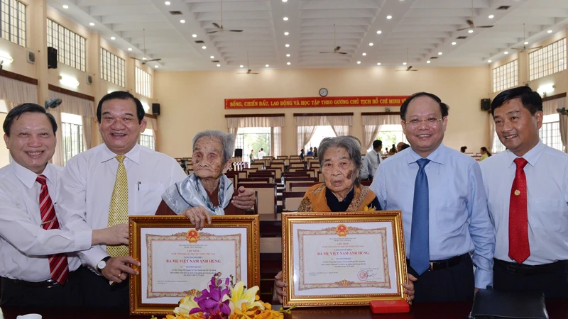 Phó Bí thư Thường trực Thành ủy TPHCM Tất Thành Cang trao danh hiệu Bà mẹ Việt Nam anh hùng cho mẹ Nguyễn Thị Rực và mẹ Nguyễn Thị Sáu. Ảnh: VIỆT DŨNG