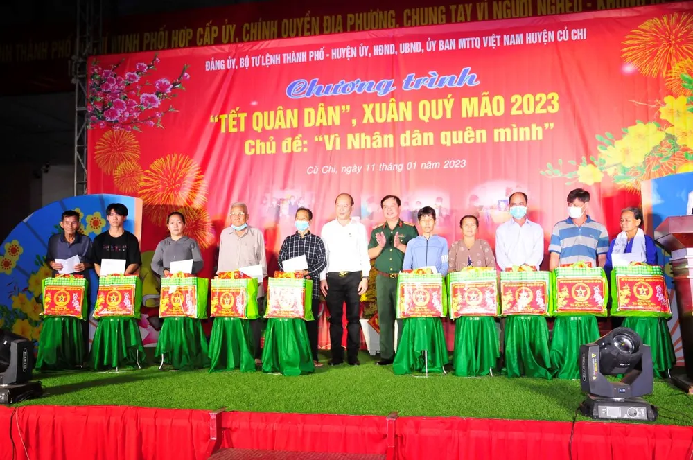 Thiếu tướng Phan Văn Xựng và đồng chí Nguyễn Quyết Thắng tặng quà cho các gia đình có hoàn cảnh khó khăn trên địa bàn huyện Củ Chi. Ảnh: TRẦN YÊN