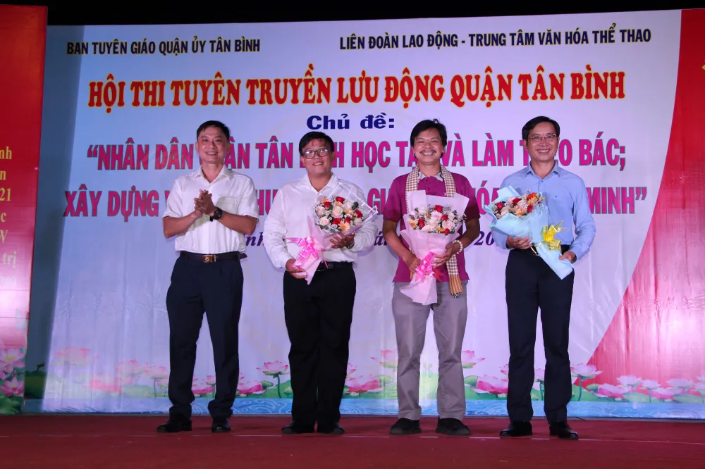 Đồng chí Nguyễn Xuân Tiến, Trưởng Ban Tuyên giáo Quận ủy, Trưởng ban tổ chức hội thi tặng hoa cho 3 thành viên Ban giám khảo hội thi. Ảnh: TRẦN YÊN