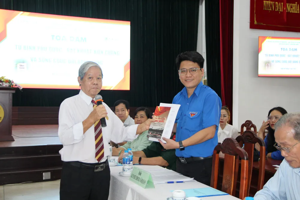 Ông Nguyễn Minh Hoàng trao lại sử liệu Cựu tù binh Phú Quốc cho thế hệ trẻ. Ảnh: TRẦN YÊN