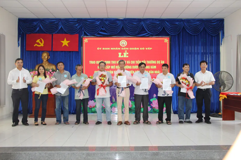 Lãnh đạo quận Gò Vấp tặng hoa chúc mừng những hộ dân đầu tiên của phường 5 nhận quyết định thu hồi đất