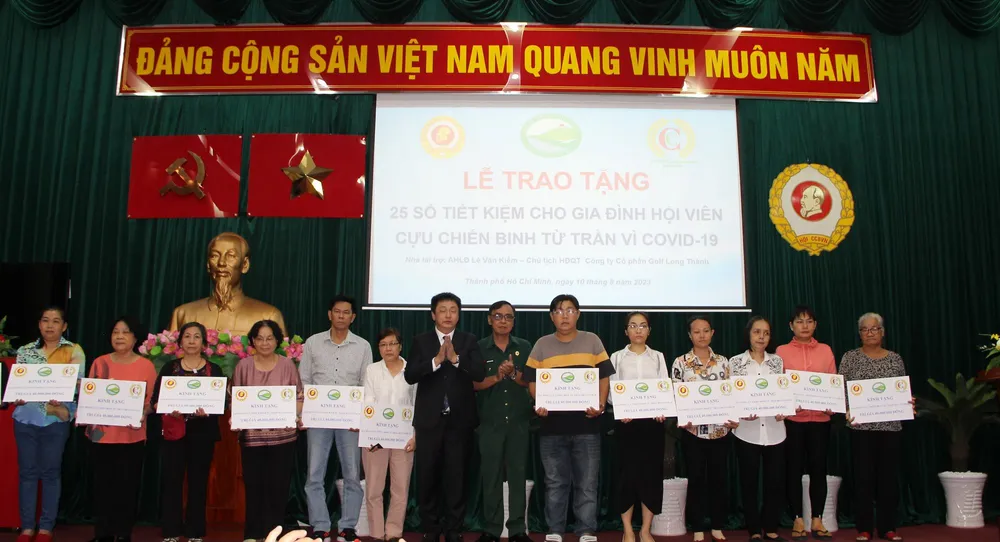 Thiếu tướng Nguyễn Minh Hoàng cùng đại diện gia đình cựu chiến binh Lê Văn Kiểm trao sổ tiết kiệm