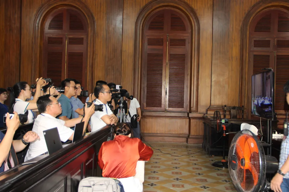 Phóng viên tác nghiệp phiên tòa tại phòng riêng, qua màn hình ti vi. Ảnh: TRẦN YÊN