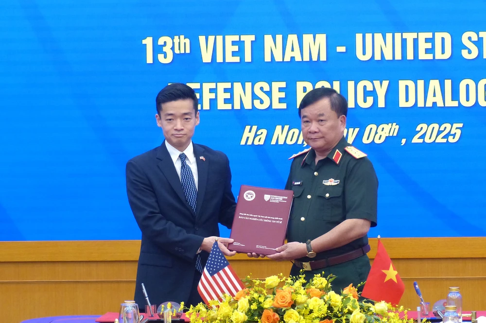 Thượng tướng Hoàng Xuân Chiến và ông John Noh trao đổi hồ sơ kỷ vật chiến tranh liên quan đến bộ đội Việt Nam. Ảnh: T.B Doi thoai QP Viet - My 9.jpg