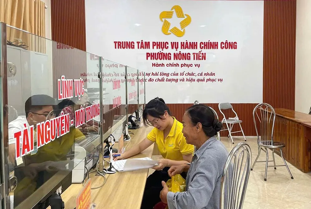 Nhân viên bưu điện tỉnh Tuyên Quang hỗ trợ người dân tại Trung tâm phục vụ hành chính công phường Nông Tiến Anh VNPost 2.jpg