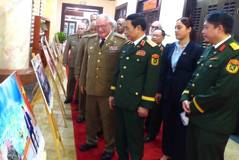 Đại tướng Phan Văn Giang và Thượng tướng Álvaro López Miera tham quan triển lãm ảnh 65 năm thiết lập quan hệ ngoại giao Việt Nam - Cuba ở trụ sở Bộ Quốc phòng trong sáng 3-9. Ảnh: TRẦN BÌNH Anh doan Bo QP Cuba 7.JPG