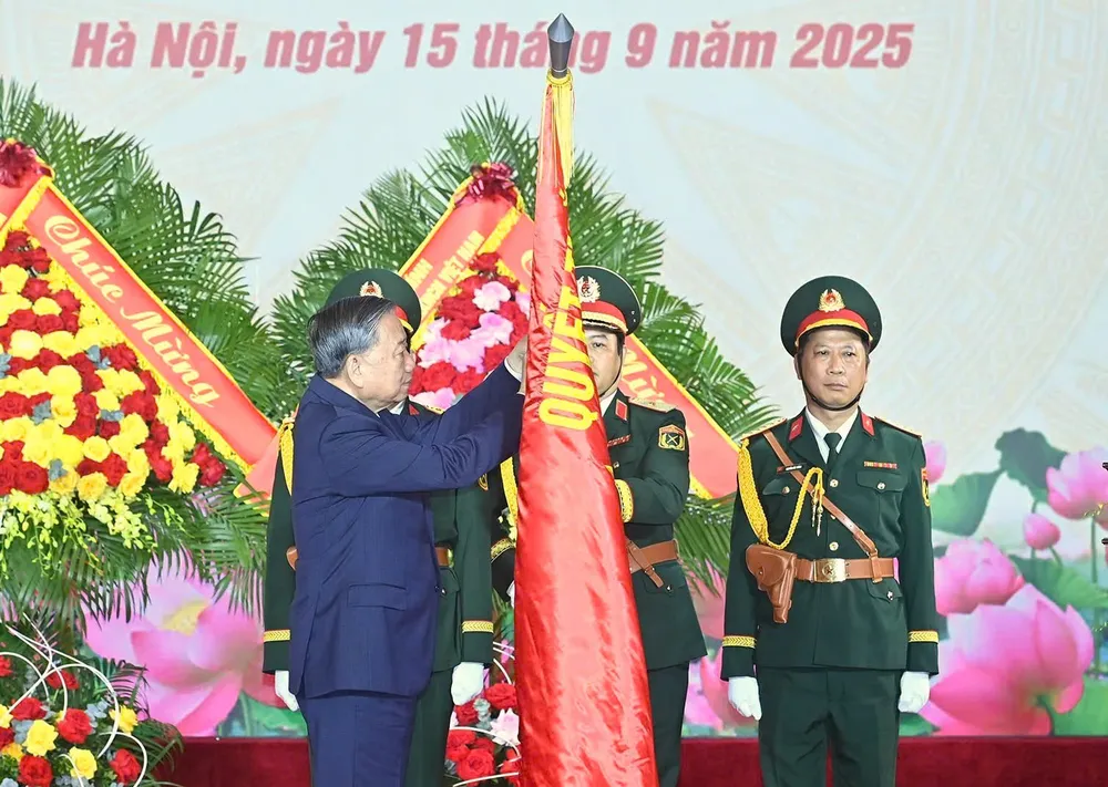 Tổng Bí thư Tô Lâm gắn danh hiệu Anh hùng Lực lượng vũ trang nhân dân lên Quân kỳ Quyết thắng của Tổng cục Công nghiệp quốc phòng tại buổi lễ. Ảnh: VIẾT CHUNG Tong cuc CNQP 7.jpg