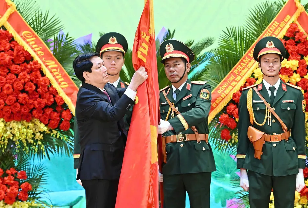 Chủ tịch nước Lương Cường gắn Huân chương Bảo vệ Tổ quốc hạng Nhất lên Quân kỳ Quyết thắng của Quân khu 3. Ảnh: VIẾT CHUNG CTN du le Quan khu Ba 4.jpg