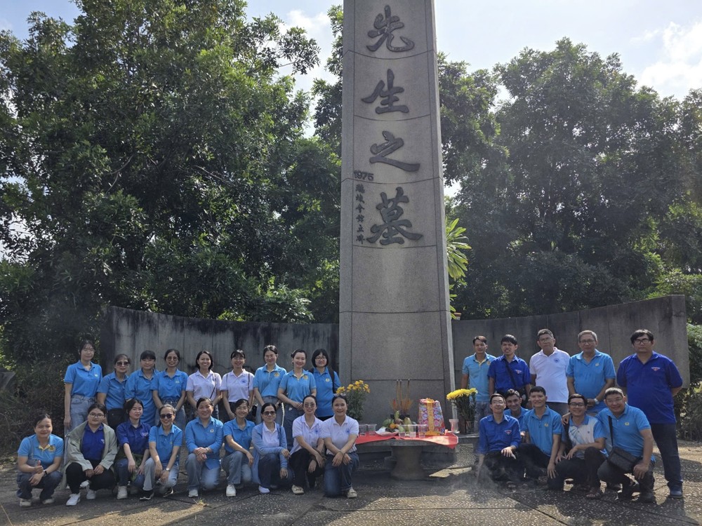 麦剑雄中学代表团在𦰡蓧坊广肇义祠麦剑雄墓碑前敬献鲜花。