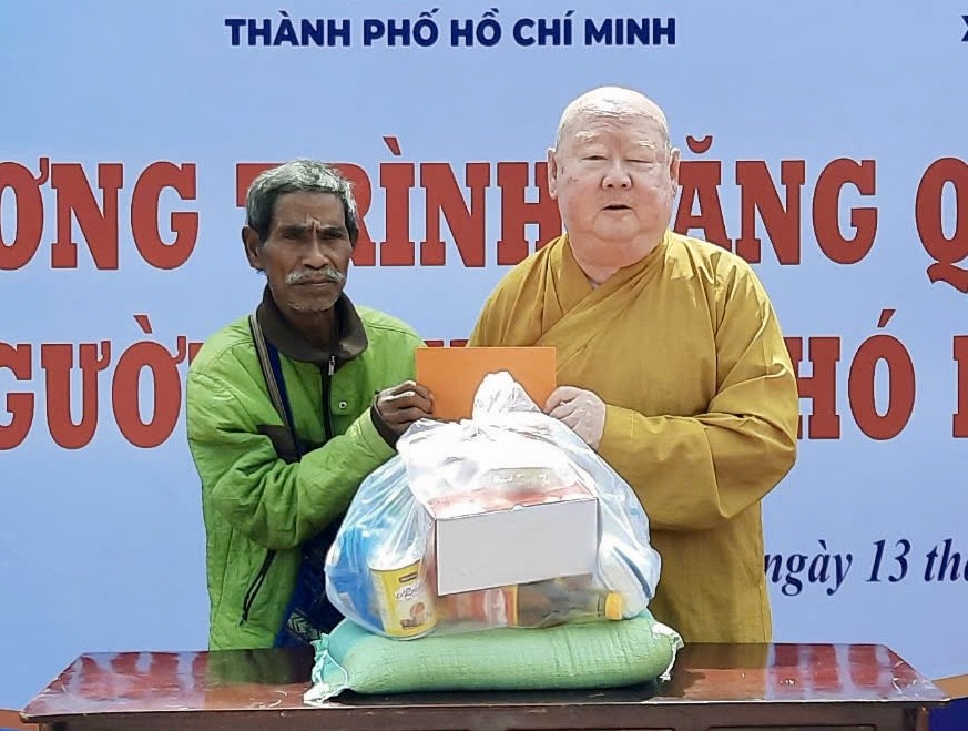 莲华寺住持释惟镇和尚向广义省少数民族同胞派发礼物。