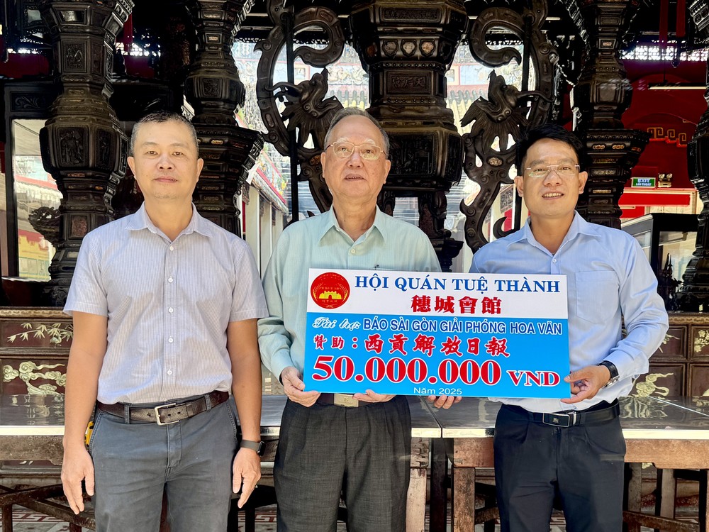 穗城会馆理事长卢耀南（中）与理事梁锦权（左）向《西贡解放报》执行编辑文忠孝（右）移交赞助经费。