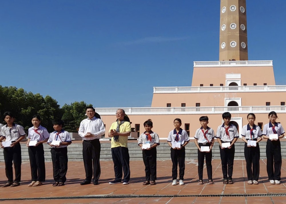 华人民运巧手穗城会馆理事长卢耀南（左五）向贫困生颁发奖学金。