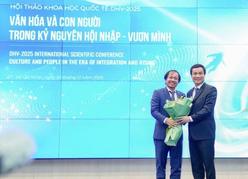 雄王大学校务委员会常务副主席、副校长陈越英博士（左）向国会文化、教育委员会副主任、副教授、博士赵世雄赠送鲜花。