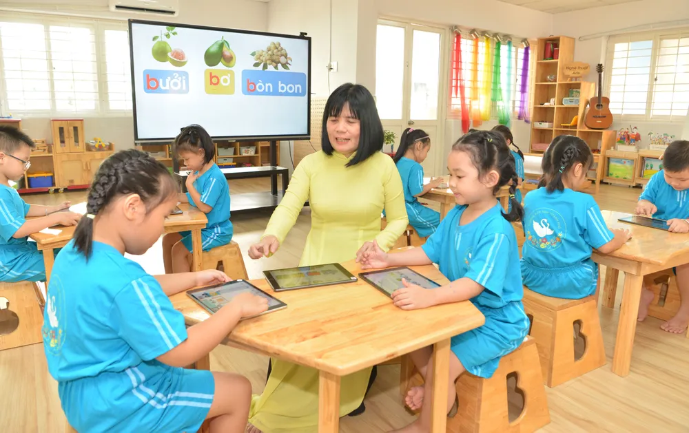 Cô Mai Yến Hằng, Hiệu trưởng Trường Mầm non Thành phố (quận 3), hướng dẫn học sinh sử dụng thiết bị công nghệ