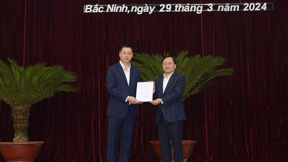 Bí thư Tỉnh ủy Bắc Ninh Nguyễn Anh Tuấn trao quyết định của Ban Bí thư cho ông Trần Huy Phương (bên trái)