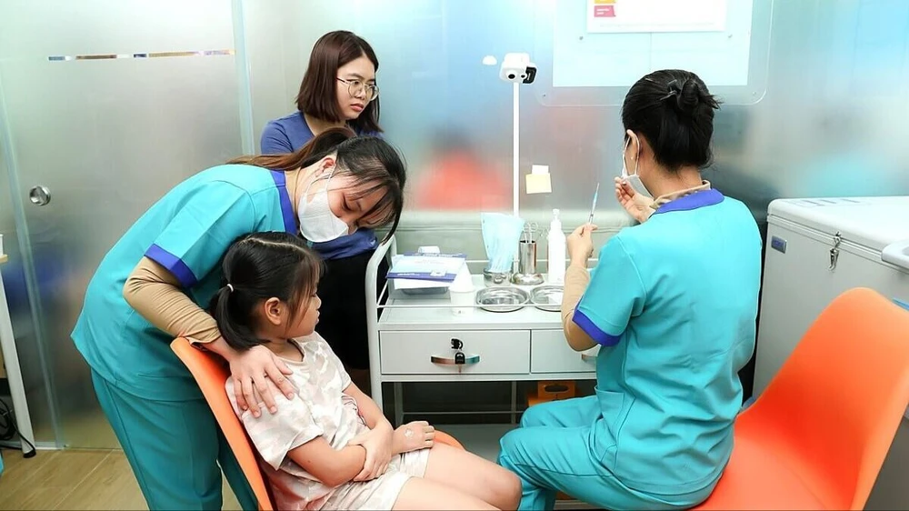 Nhân viên Trung tâm tiêm chủng Long Châu đang tiêm vaccine cho trẻ