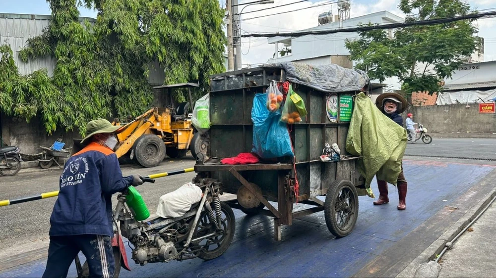 Người thu gom rác dân lập cân tại trạm cân ở xã Bà Điểm, huyện Hóc Môn. Ảnh: THANH HIỀN