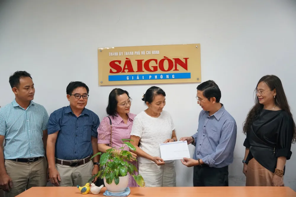 Ông Nguyễn Thành Lợi, Phó Tổng Biên tập Thường trực Báo SGGP, tiếp nhận tiền phúng điếu từ bà Nguyễn Thị Thùy Vân (vợ bác sĩ Nguyễn Văn Thành). Ảnh: VIỆT NGA Z4e.jpg