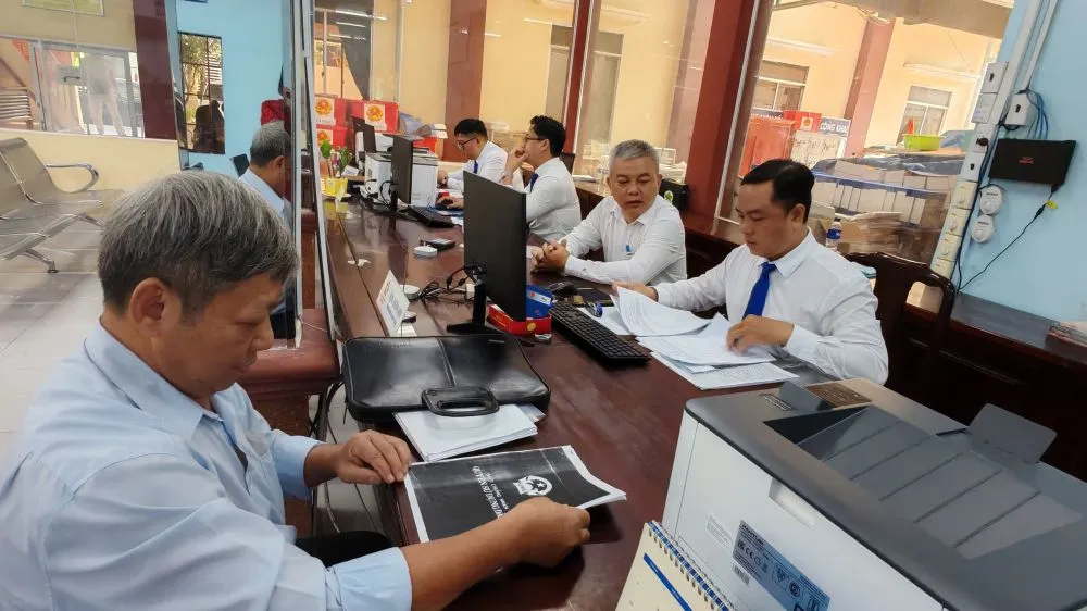 Ông Phạm Đình Oanh (trái), người dân phường Phú Lợi đến làm thủ tục hành chính về đất đai tại Trung tâm hành chính công của phường phuongphuloi.jpg
