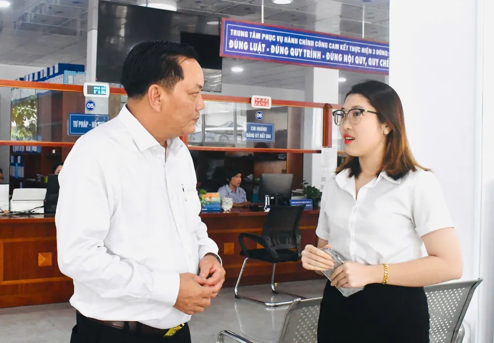 Ông Đặng Văn Hùng, Chủ tịch UBND phường Phú Mỹ trao đổi cùng người dân về việc tiếp nhận thủ tục hành chính ngày 1-7. Ảnh: HUYỀN TRANG z6760925869130_dde7e4e6cd4e2b06b2b61fd618655f99.jpg