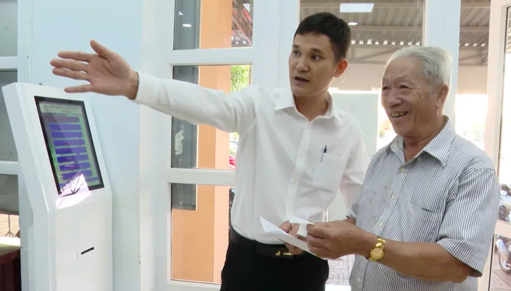 Công chức Trung tâm Phục vụ hành chính công xã Hòa Hiệp hướng dẫn người dân làm thủ tục hành chính. Ảnh: HUYỀN TRANG z6760961345400_69e210948ce7b61d34e9ec3adc5a680c.jpg