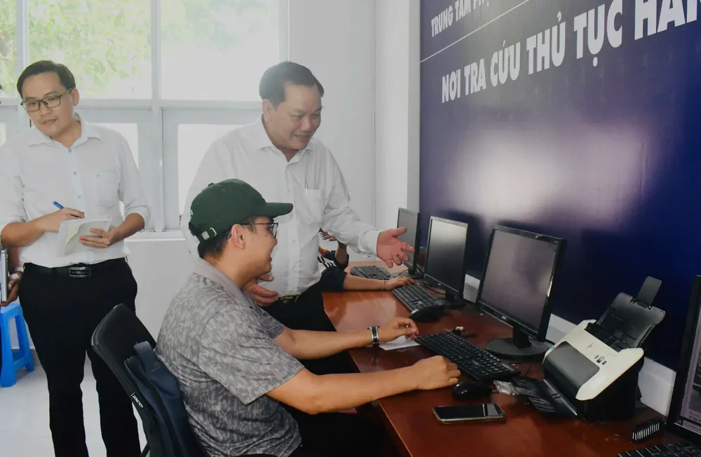 Ông Đặng Văn Hùng, Chủ tịch UBND phường Phú Mỹ trao đổi cùng người dân về thủ tục hành chính trực tuyến ngày 1-7. Ảnh: HUYỀN TRANG z6761031402627_3859fa241151479bb9d5a39e775e5b65.jpg