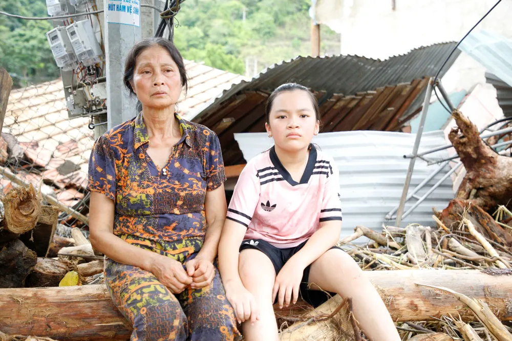 Bà Đậu Thị Hợp và cháu Trần Thị Hoài An (xã Tương Dương, tỉnh Nghệ An) trước ngôi nhà bị lũ đánh sập hoàn toàn. Ảnh: Duy Cường Z7a.jpg