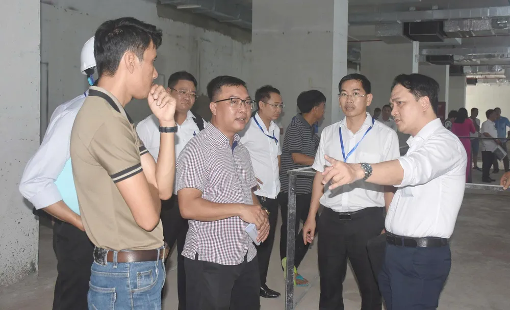 Cơ quan chức năng kiểm tra tại khu vực tầng thương mại của chung cư Lapen. Ảnh: QUANG VŨ 1 lapen.jpg